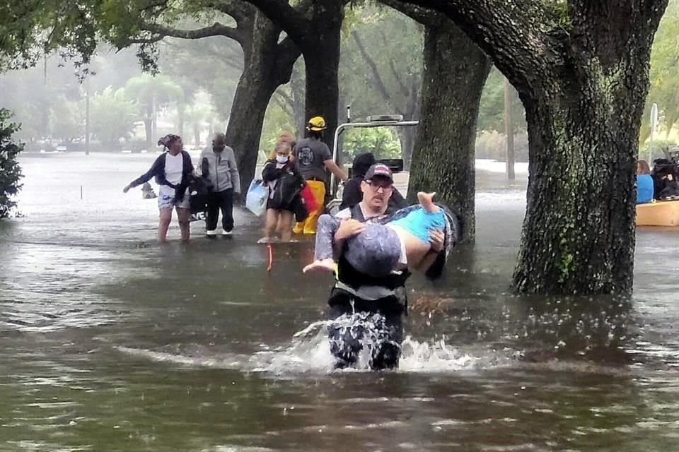 Bomberos ayudan a personas que quedaron atrapadas en las inundaciones, en Orange County, Florida.