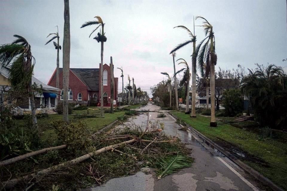 Árboles y escombros tirados en una calle de  Punta Gorda, Florida, después del paso de 'Ian'.