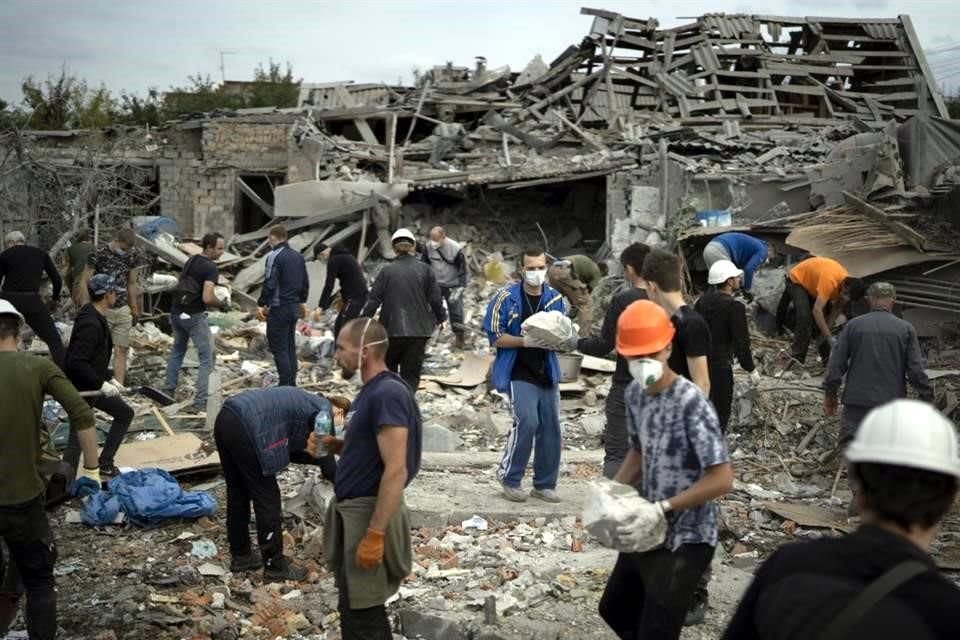 Voluntarios trabajan en una zona residencial donde cayeron cohetes rusos.