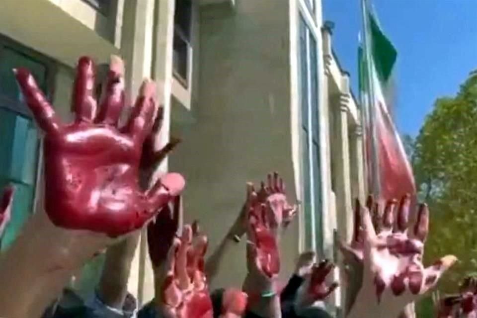 Estudiantes de la Facultad de Artes de la Universidad de Azad en Teherán participan en una protesta con las manos pintadas de rojo para simbolizar la sangre que corre a causa de la represión.