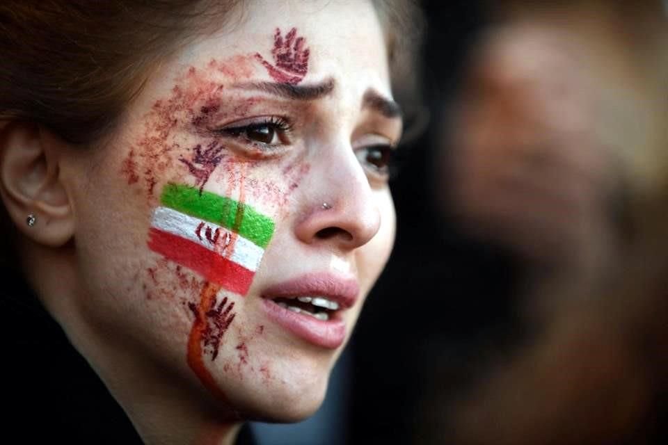 Una mujer con la bandera de Irán dibujada en el rostro participa en una protesta en París.