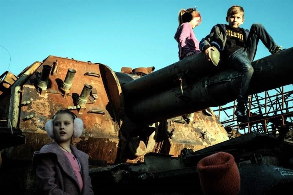 Niños ucranianos trepan a un tanque ruso exhibido en la capital de Ucrania, Kiev.