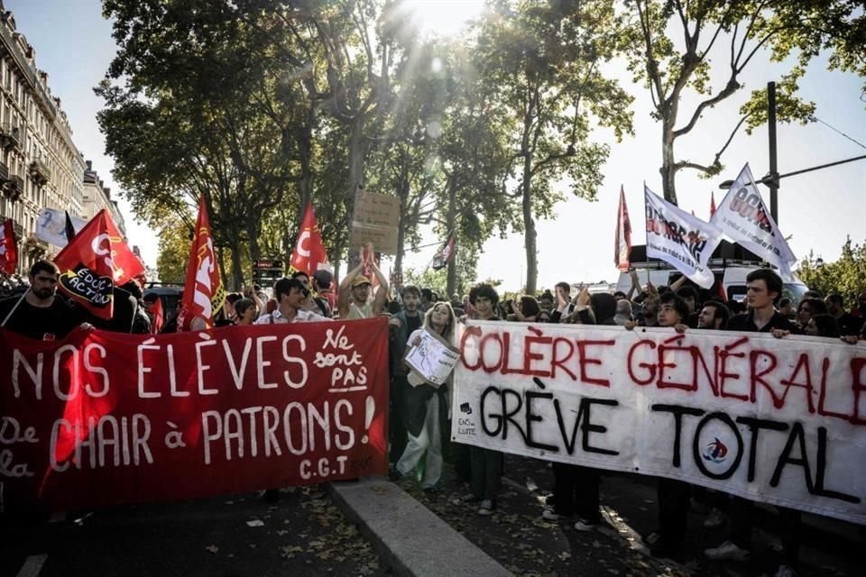 Manifestantes en París sostienen un cartel con la leyenda 'Enfado general, huelga total'.