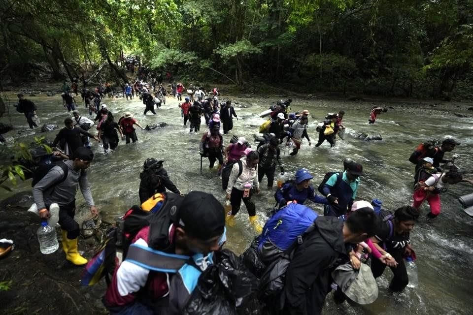 Un grupo de migrantes cruzan un río en la selva del Darién, entre Panamá y Colombia.