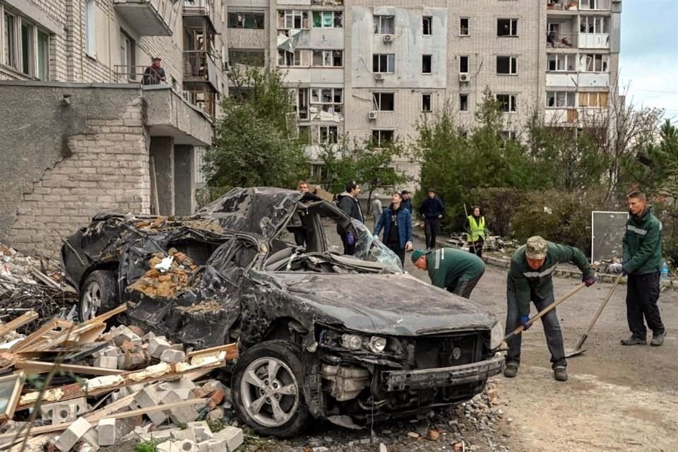 Personas en Mykolaiv limpian un área residencial después de ataques rusos en la zona.