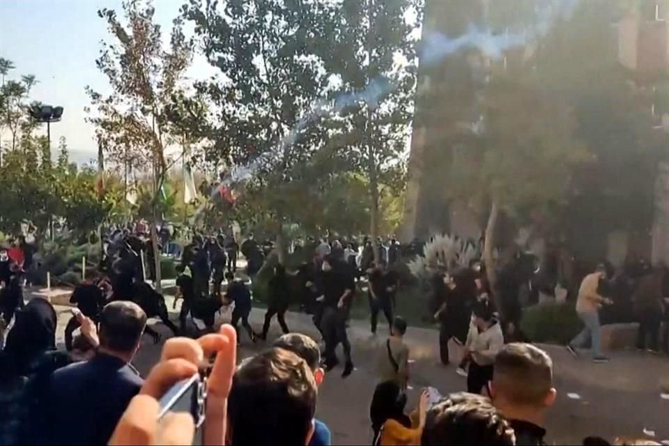 Manifestantes de la Universidad del Norte de Teherán evitan proyectiles durante choques con autoridades el domingo pasado.