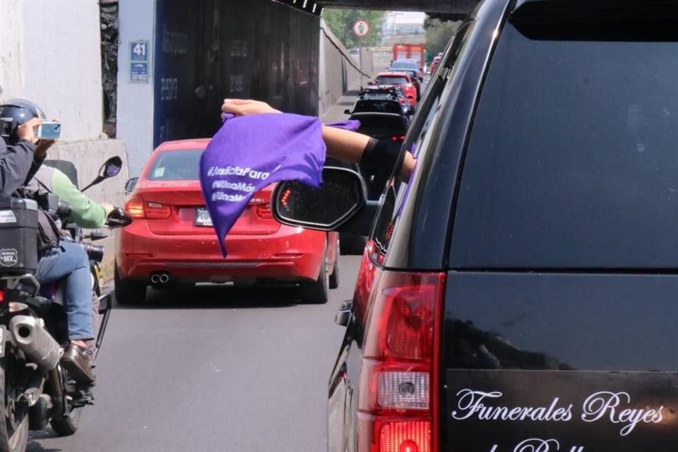 En una de las ventanillas de la carroza que trasladó a Ariadna se desplegó un pañuelo morado en protesta contra el reporte de las autoridades morelenses.