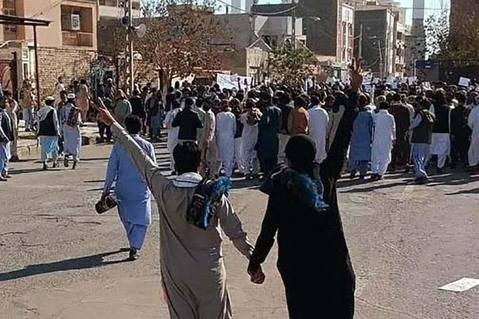 Dos iraníes se toman de las manos durante una protesta en la ciudad de Zahedan.