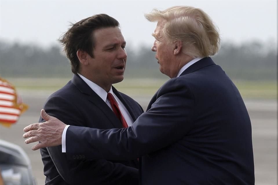 El entonces Presidente Donald Trump estrecha la mano del Gobernador de Florida Ron DeSantis cuando llega a la Base de la Fuerza Aérea Tyndall para ver los daños causados por el huracán Harris en 2019.