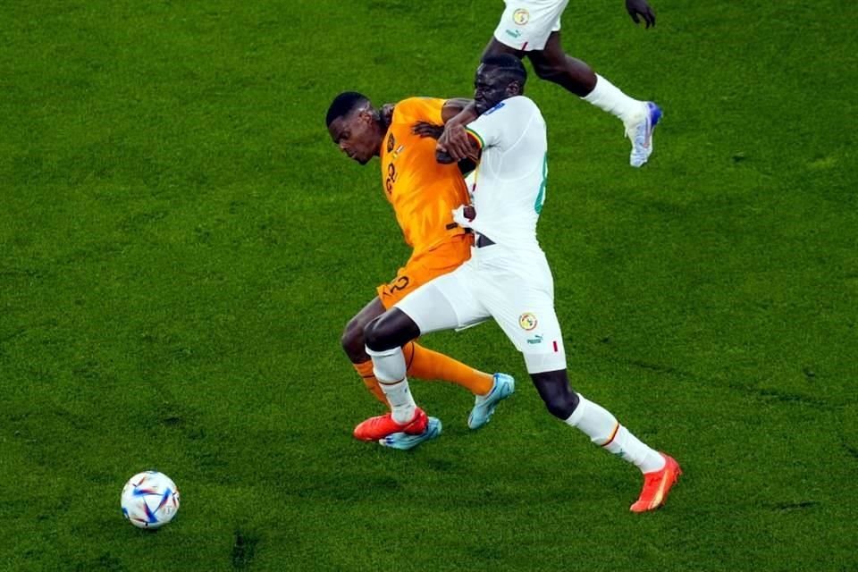 Cheikhou Kouyate, de Senegal, desplazando a Denzel Dumfries en busca de la redonda.