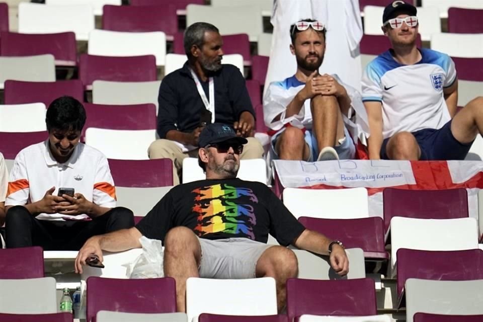 Un hincha de Inglaterra con una camiseta arcoíris se sienta en las gradas.