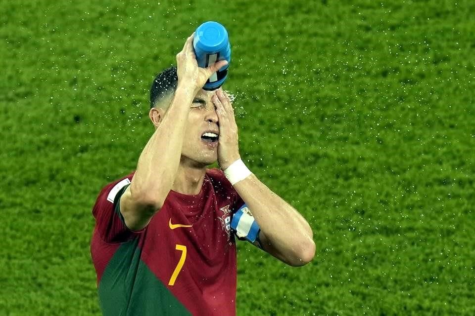 Cristiano Ronaldo se refresca con un bote de agua.