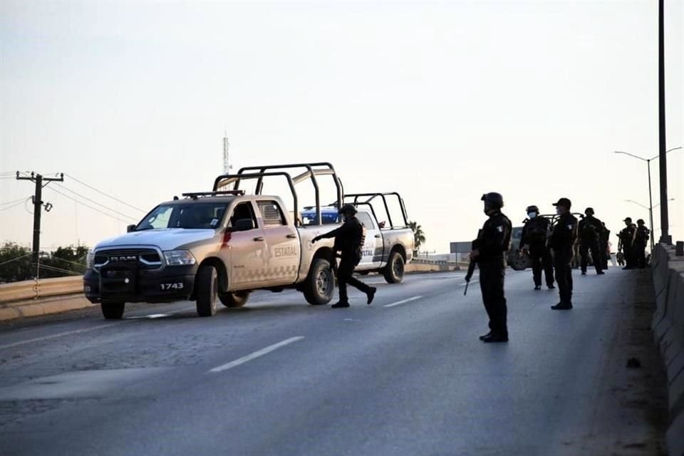 Elementos de la Policía estatal resguardan una avenida en Nuevo Laredo tras los hechos violentos de esta mañana.