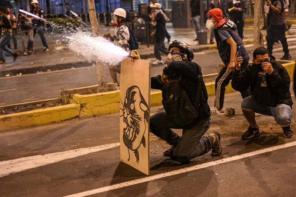 Partidarios del ex Presidente Pedro Castillo lanzan petardos a la Policía antidisturbios durante una protesta cerca del Congreso en Lima.