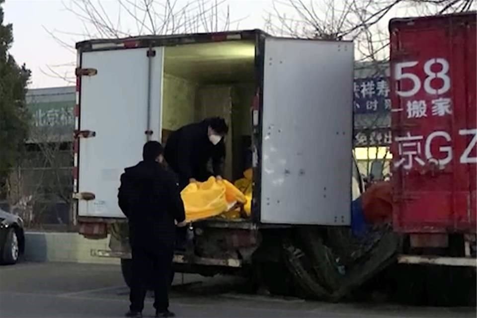 Trabajadores cargan bolsas para cadáveres en un camión en un complejo funerario en Beijing.