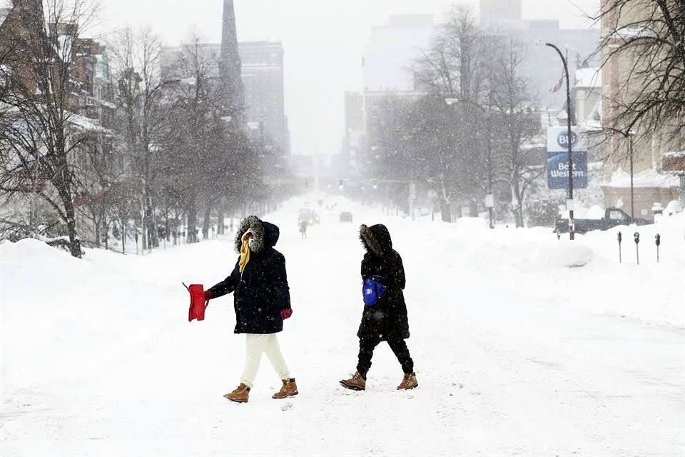 Peatones cruzan la calle en Delaware Avenue durante la tormenta de nieve en Búfalo, Nueva York.