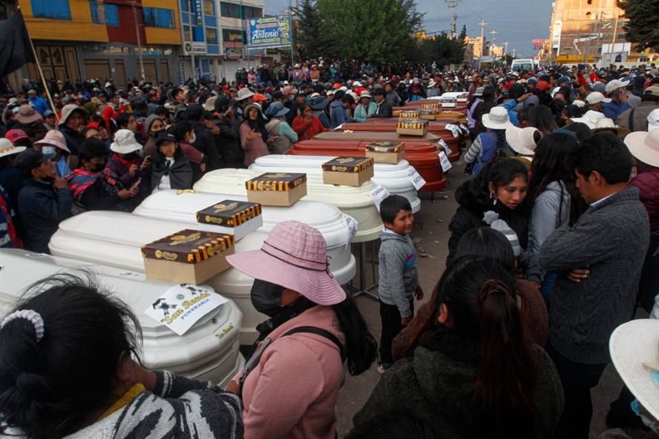 Familiares de las 17 personas fallecidas en los enfrentamientos con las fuerzas de seguridad esperan con los ataúdes vacíos afuera de la morgue en Juliaca.