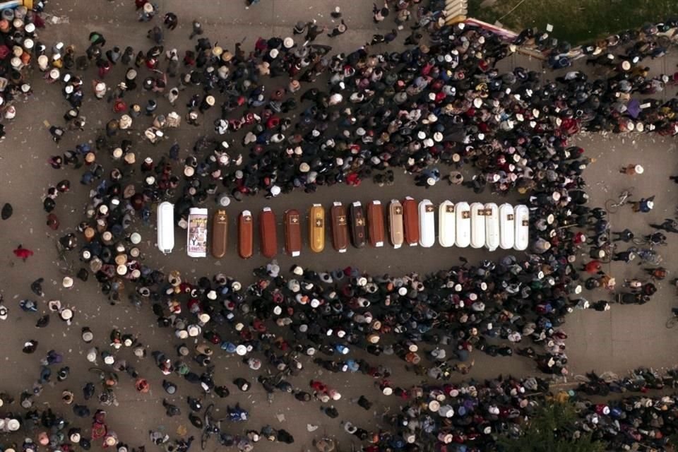 Los residentes rodean ataúdes durante una vigilia por la muerte de más de una docena de personas durante los disturbios en Juliaca, Perú.