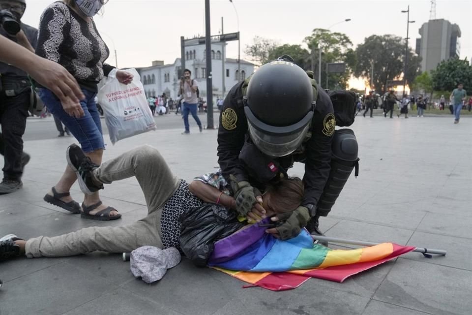 Un oficial ayuda a un manifestante antigubernamental que colapsó por los gases lacrimógenos.