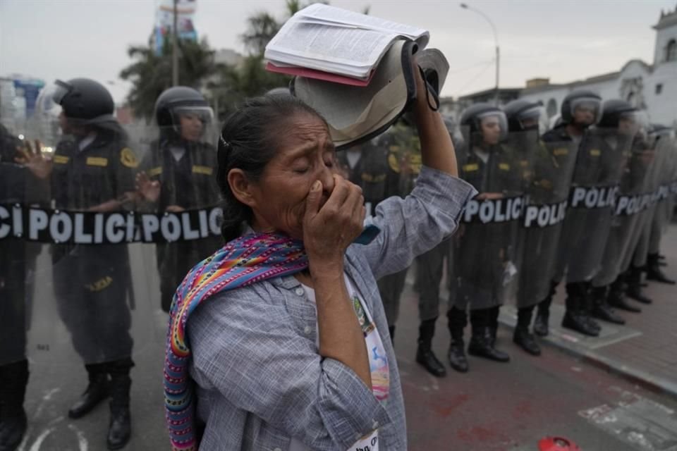 Una mujer con una Biblia en mano protesta frente a la Policía en Lima.