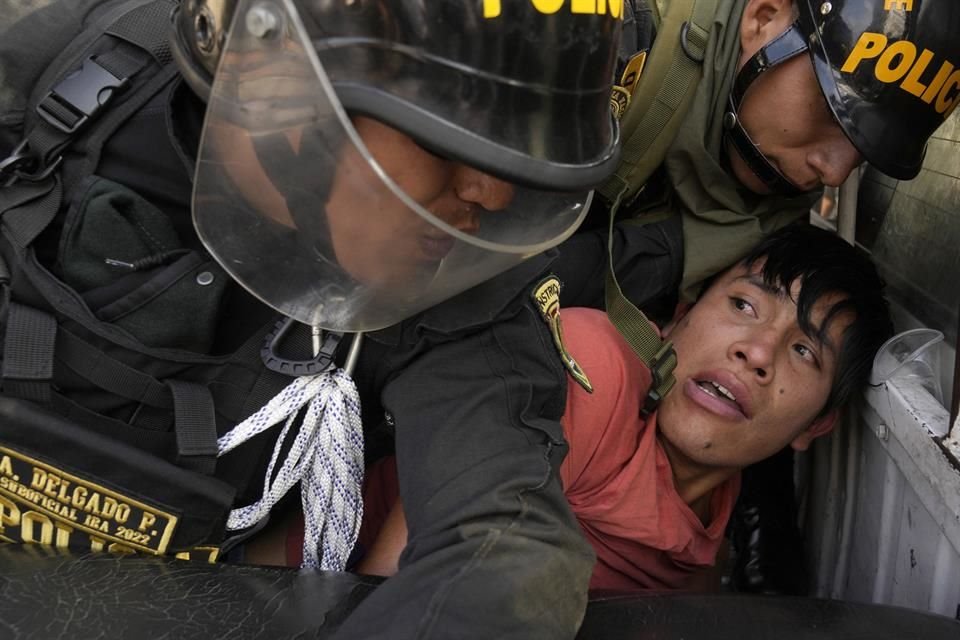 Policías antidisturbios detienen a una mujer.