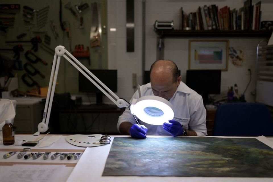 Un empleado del Senado trabaja en la restauración de una pintura que resultó dañada durante la incursión de simpatizantes del expresidente Bolsonaro en la sede legislativa .