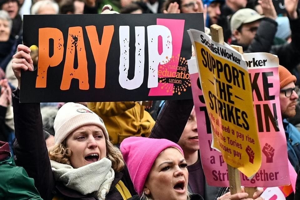 Los maestros sostienen una pancarta mientras gritan consignas en una protesta organizada por su sindicato en la plaza de San Pedro, en Manchester.