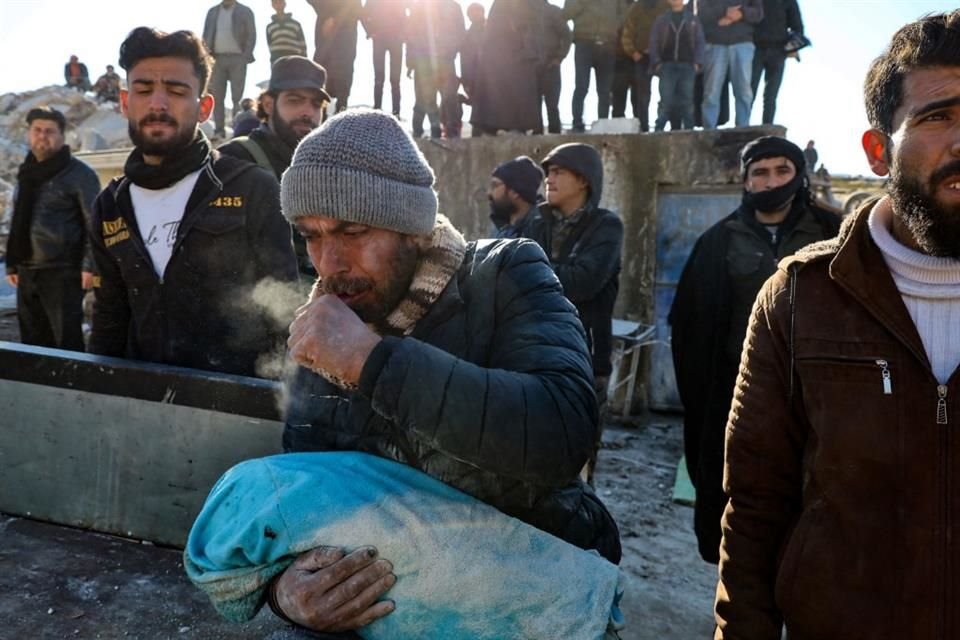 Un hombre carga el cuerpo de su bebé sacado de los escombros en Harim, en la provincia siria de Idlib controlada por los rebeldes.