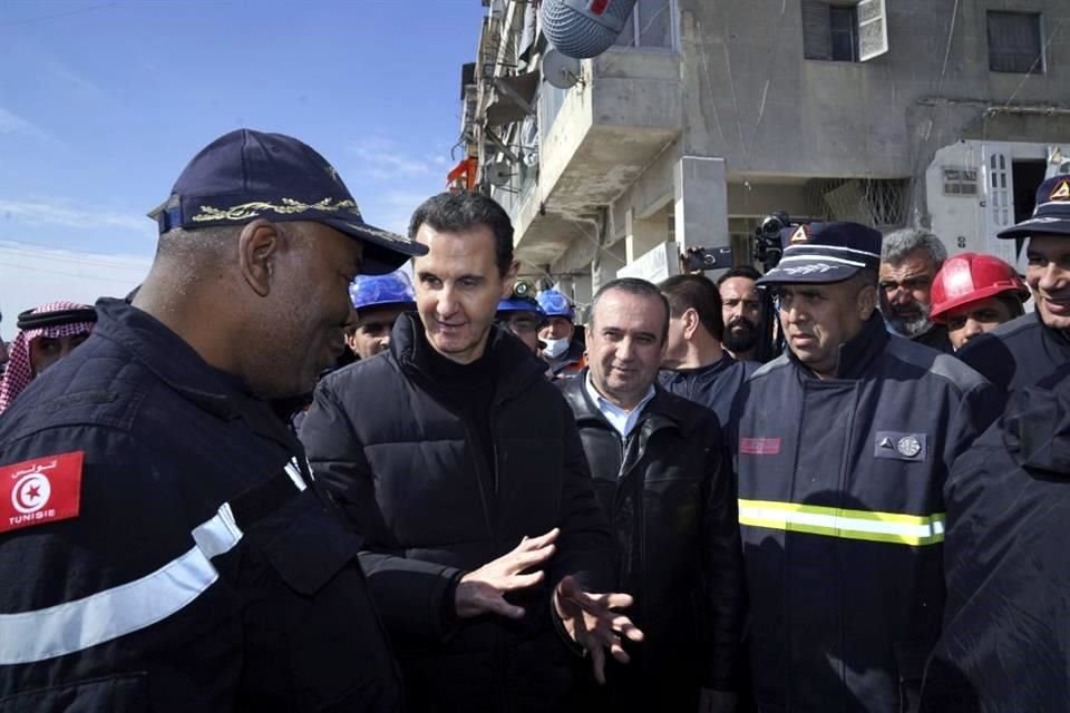 El Presidente sirio, Bashar Assad, segundo a la izquierda, habla con un equipo de rescate argelino en el lugar de los edificios destruidos tras el devastador terremoto.