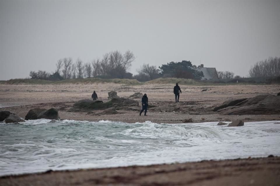 Personas vestidas de negro buscan paquetes de droga en las costas francesas.