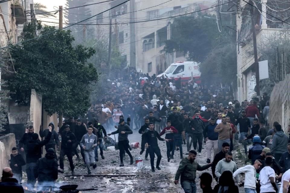 La gente huye durante los enfrentamientos con las fuerzas israelíes en una redada del Ejército israelí en el campo de refugiados palestinos de Jenin en la Cisjordania ocupada.