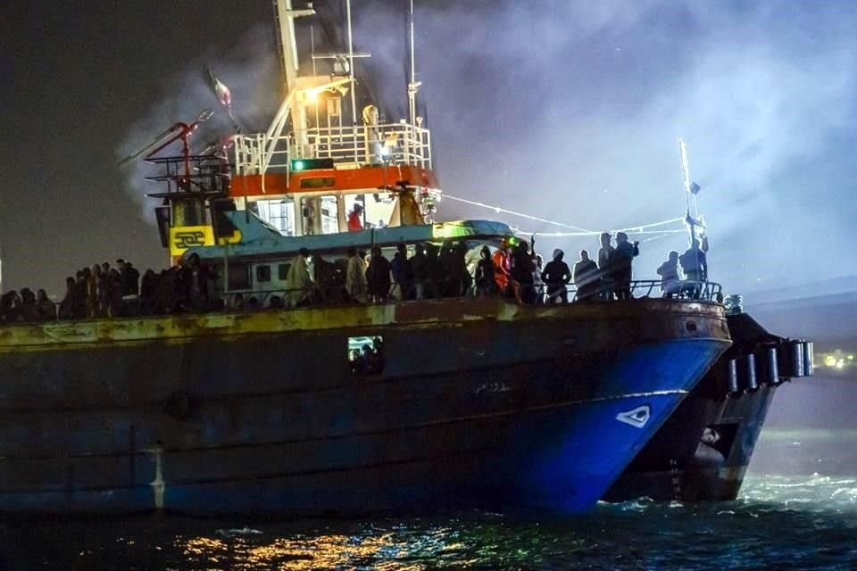 Cientos de migrantes a bordo de una embarcación pesquera a su llegada al puerto de Crotona.