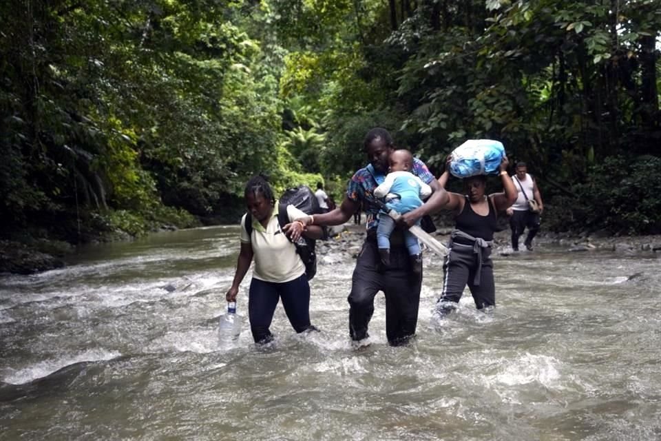 Migrantes haitianos cruzan un río del Tapón del Darién, de Colombia a Panamá, con la esperanza de llegar a EU.