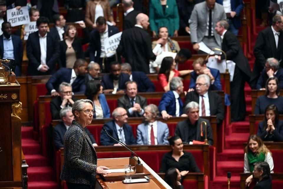 Miembros del Parlamento de la coalición de izquierda sostienen pancartas antes del inicio del discurso de la Primera Ministra de Francia, Elisabeth Borne.