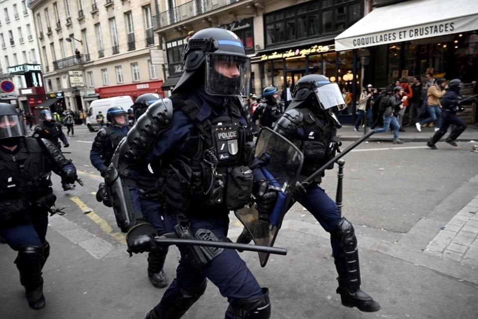 Agentes de la Policía antidisturbios franceses corren hacia los manifestantes durante una manifestación contra las reformas de las pensiones en París.