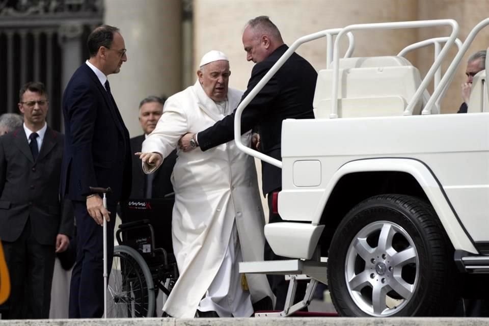 Papa Francisco es ayudado a subirse a su automóvil al final de la audiencia general semanal en la Plaza de San Pedro, en el Vaticano.