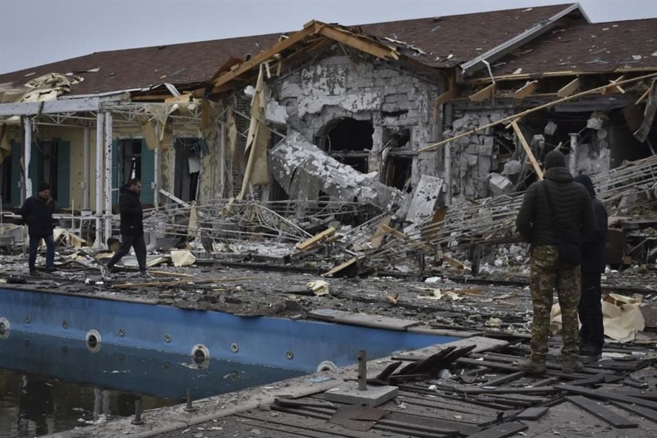 Varias personas inspeccionan un restaurante dañado por un bombardeo ruso en Zaporiyia, Ucrania, el 18 de marzo de 2023.