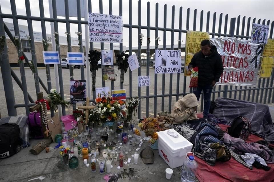 Un altar con velas y fotos cubre la cerca afuera del centro de detención de migrantes en el que murieron 40 personas.