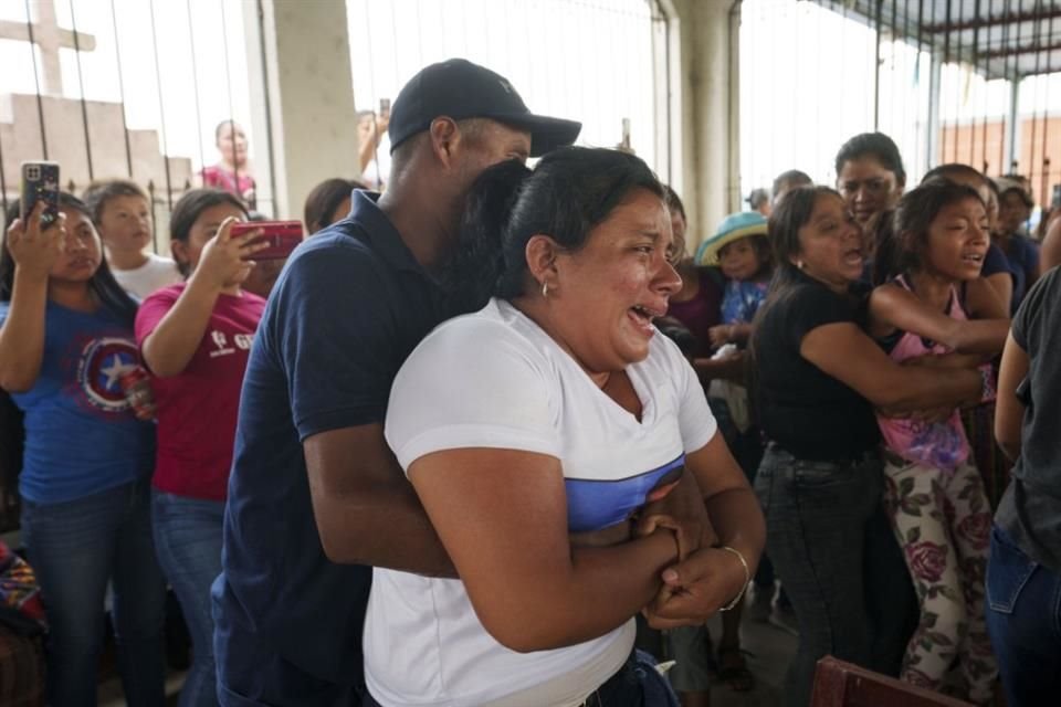 Familiares de dos migrantes fallecidos en un incendio en México durante el entierro en Guatemala.