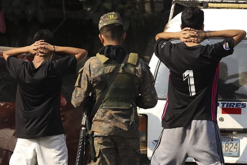 Un militar comprueba la identidad de dos jóvenes en plena calle en el barrio de La Campanera en Soyapango, El Salvador, el domingo 5 de marzo de 2023.