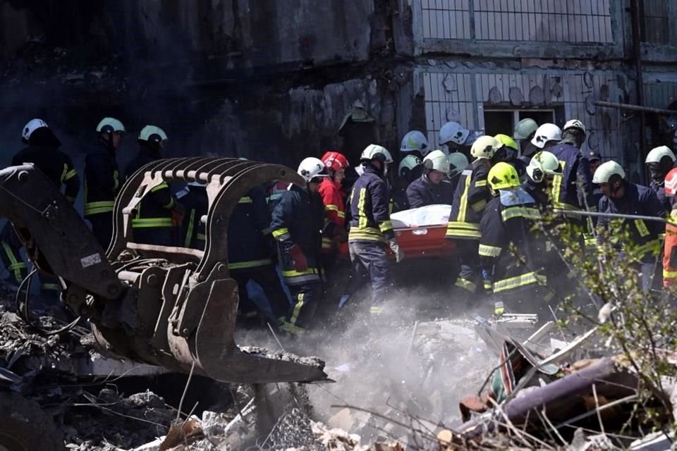 Los rescatistas llevan el cuerpo de un residente local, junto a un edificio residencial dañado en Uman.