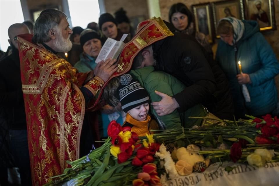 Familiares y amigos lloraron junto a los ataúdes de niños y otras personas que murieron en un ataque con un misil ruso en Uman.