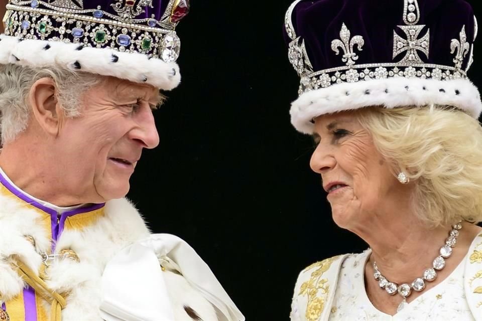 El rey Carlos III de Gran Bretaña y la reina Camila se miran desde el balcón del Palacio de Buckingham después de su coronación, en Londres.