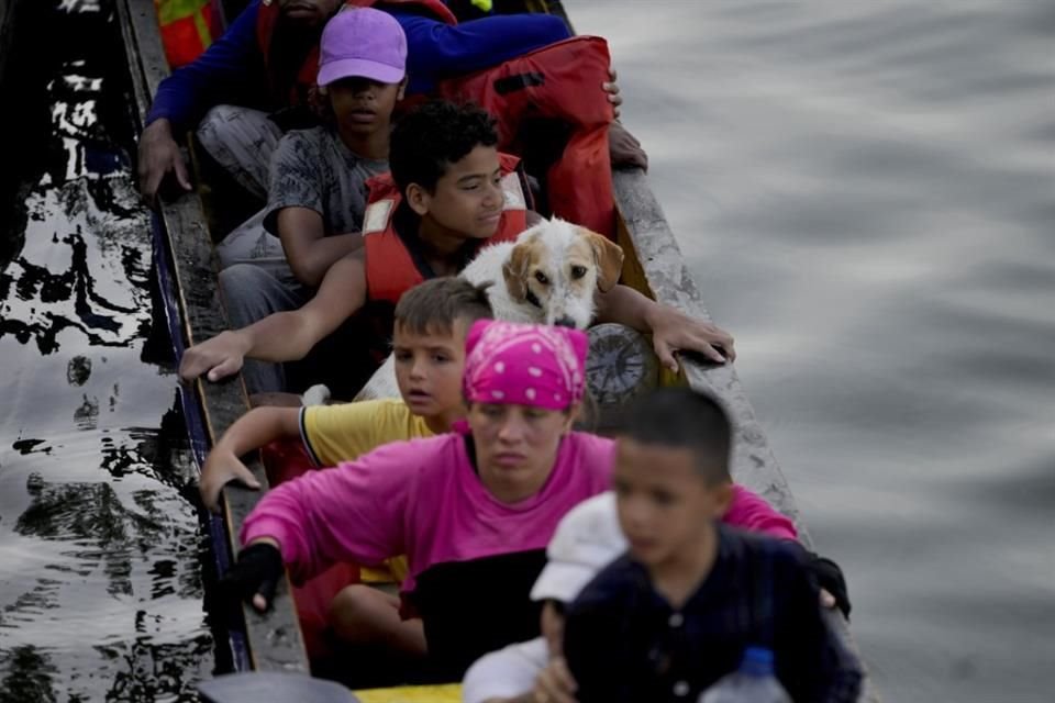 Joshua Morales viaja con su perro Toby en un bote de migrantes, tras cruzar la selva del Darién, desde Colombia, el 6 de mayo.