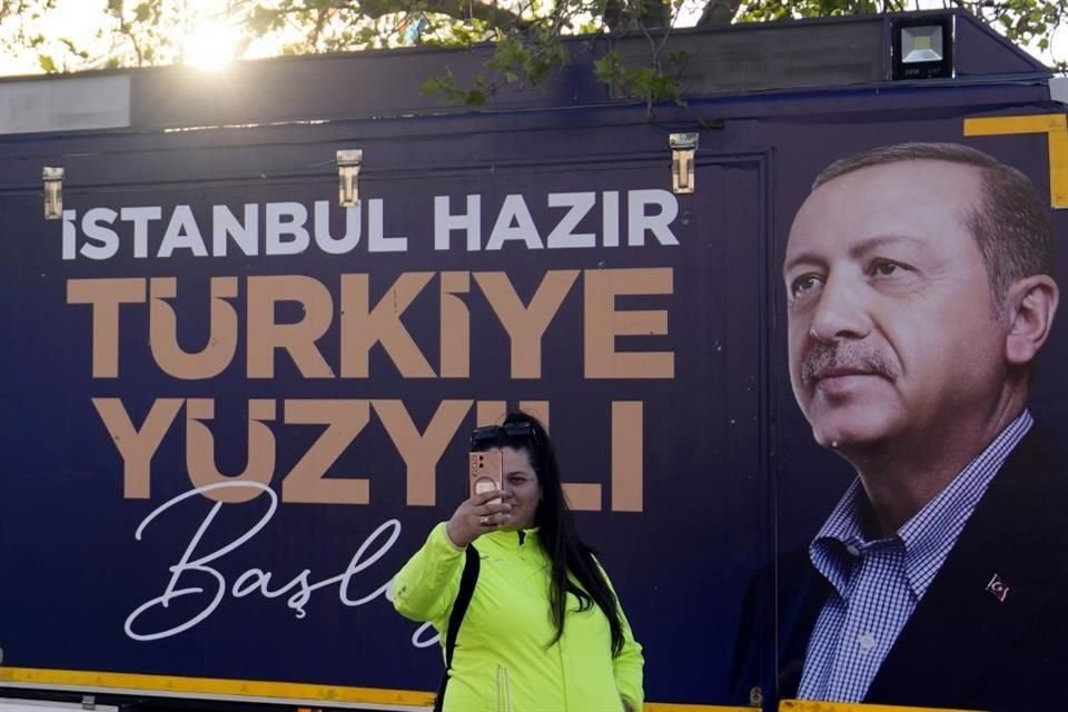 Una mujer se toma una selfie con un cartel del Presidente turco y candidato presidencial de la Alianza Popular, Recep Tayyip Erdogan.