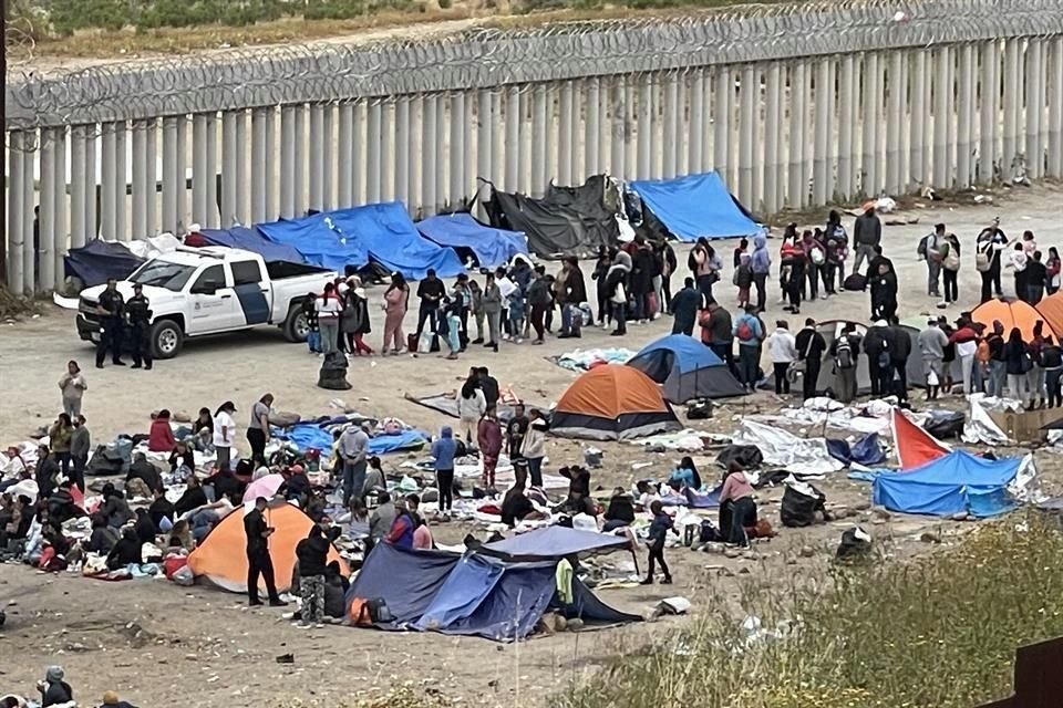 Migrantes esperan ser llevados por agentes del Buró de Aduanas y Protección Fronteriza (CBP) entre los dos muros colocados por Estados Unidos, a la altura de la colonia El Soler, en Tijuana.