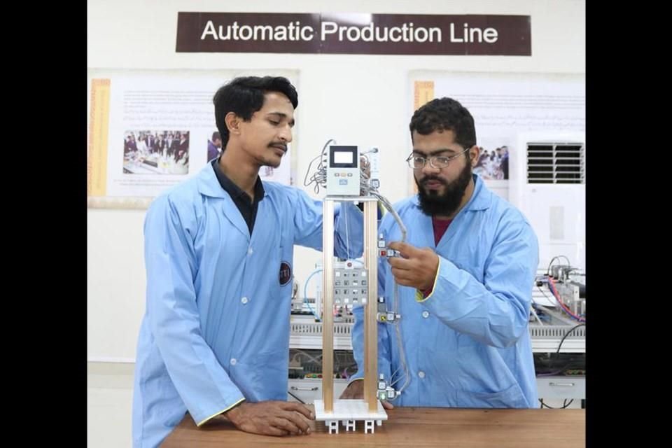 Estudiantes aprenden a operar ascensores en una clase de automatización y robótica de un Taller de Luban.
