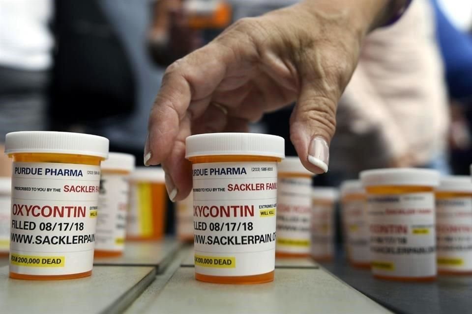 Familiares y amigos que han perdido a seres queridos por OxyContin y sobredosis de opioides dejan frascos de pastillas en protesta frente a la sede de Purdue Pharma, en Stamford, Connecticut.