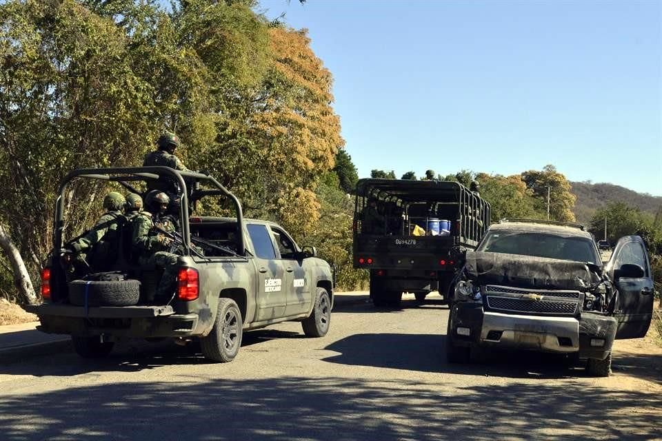 Soldados del ejército pasan frente a un vehículo destruido en las calles de Jesús María, México, el pequeño pueblo donde Ovidio Guzmán fue detenido en enero.