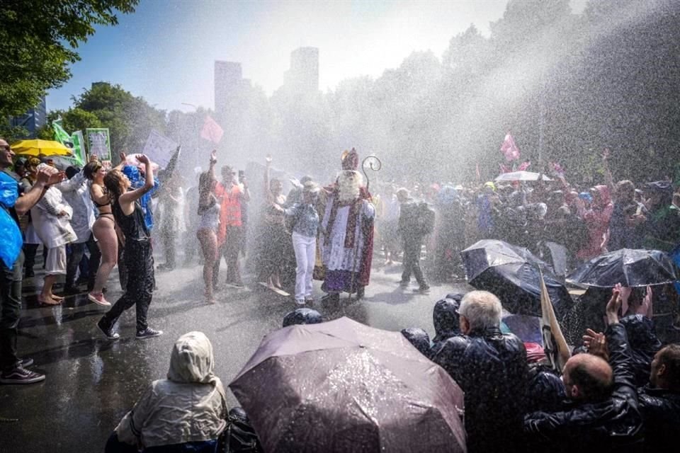 Activistas de Extinction Rebellion bloquean la A12 mientras la policía antidisturbios usa cañones de agua para dispersarlos.